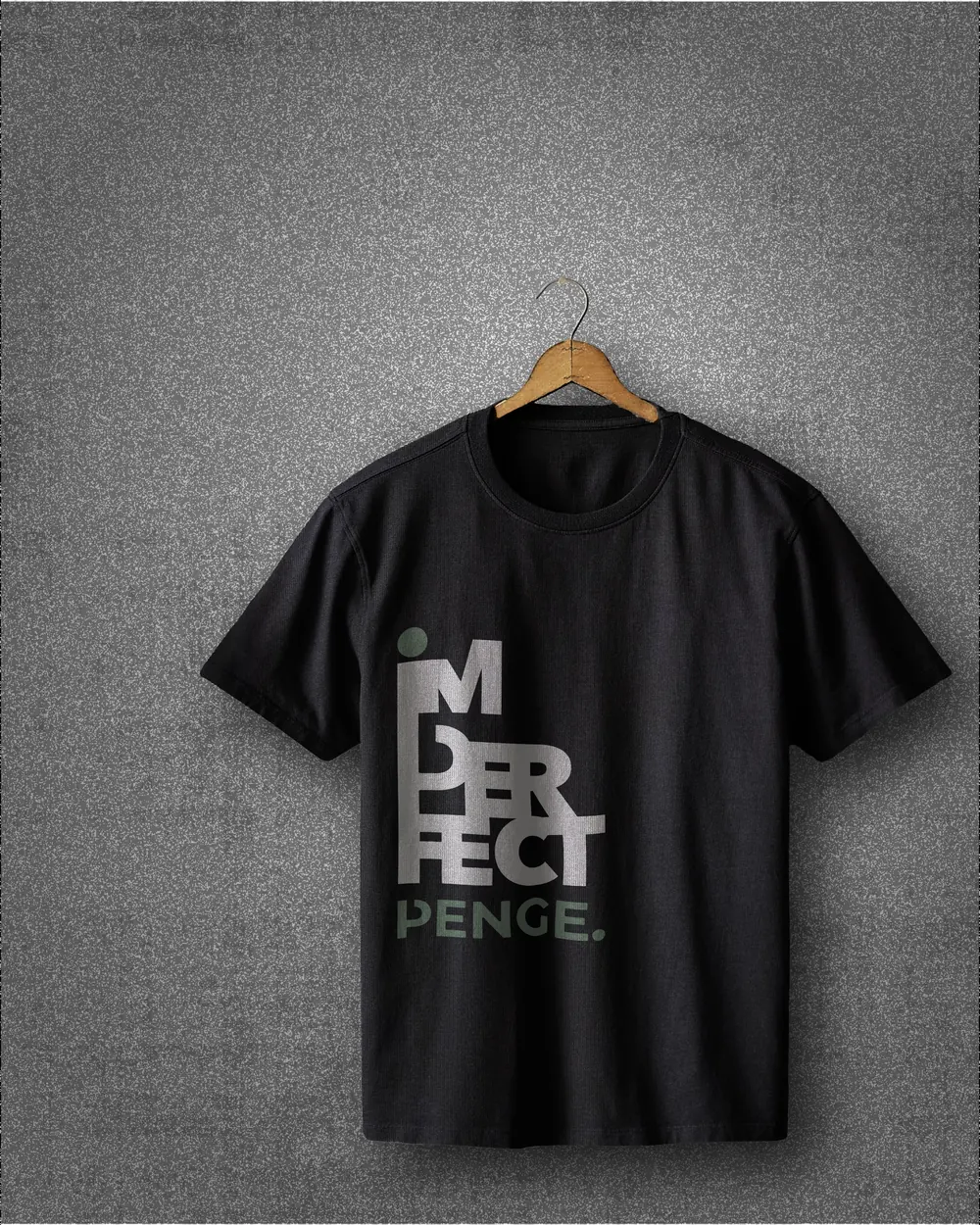 Black IMPERFECT tee on a wooden hanger against a grey wall